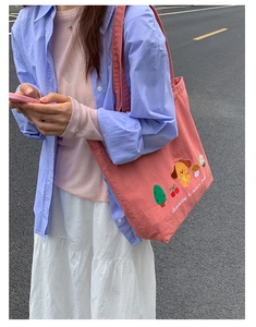 Close-up of pink denim tote bag featuring cute cartoon dog and forest embroidery