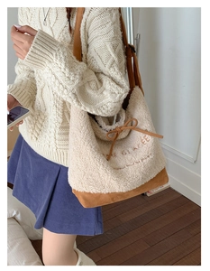 Detail of faux shearling and suede tote bag with brown embroidery and bow detail