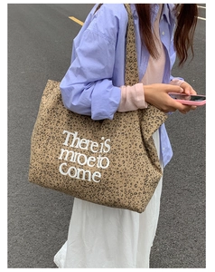 Close-up of leopard print canvas tote bag with white letter print in street style