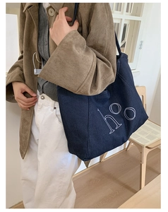 Detail of vintage navy denim tote bag with white hoo letter print and reinforced strap