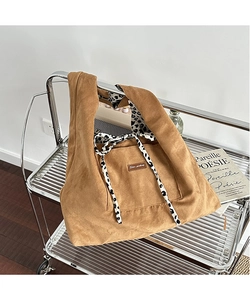 Detailed close-up of corduroy tote bag showing leopard print lining and logo patch