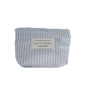 Blue striped canvas makeup bag with embroidered bows and minimalist patch design