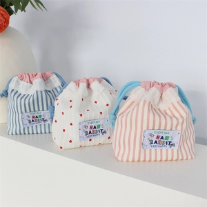 Detailed view of lace trim and drawstring on striped and heart pattern storage bags