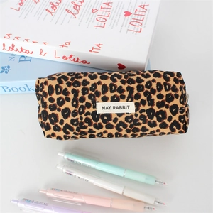 Close-up of leopard print canvas pencil case with brand label and stationery details