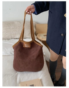 Close-up of dark brown suede tote bag featuring Bonjour label and thick fabric texture
