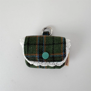 Detail of plaid tweed earphone case with lace trim and secure metal carabiner clip