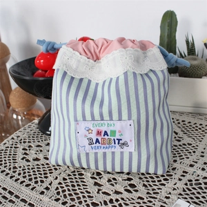 Detail of cute lace trim and drawstring closure on mint green striped organizer bag