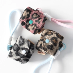 Three plush leopard print earphone cases in pink, grey, and brown with colorful buttons