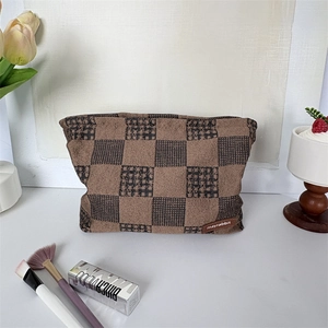 Détail de la trousse de maquillage épaisse tissée à damier avec étiquette de marque