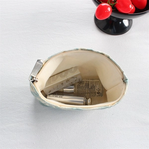 Macro view of compact floral canvas makeup pouch showing lipstick storage capacity