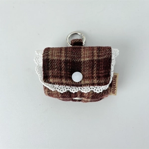 Close-up of retro plaid earphone case with white lace trim and silver metal ring hook