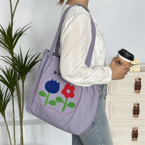 Detail der fliederfarbenen Kordelzug-Tasche mit Tulpenmuster als Schultertasche