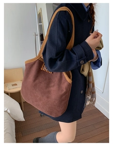 Close-up of brown suede tote bag featuring contrasting yellow knit shoulder strap
