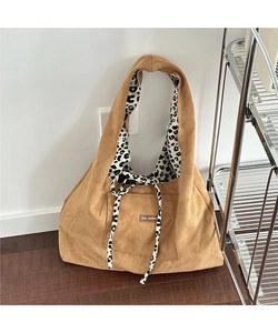 Detail of hobo tote bag with brown corduroy exterior and leopard print lining ties
