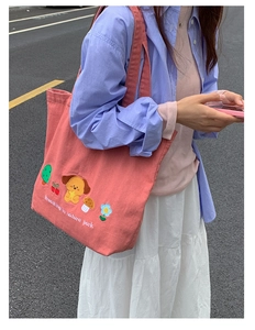 Close-up of pink canvas tote bag featuring exquisite cartoon embroidery and floral details