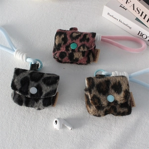 Macro detail of plush leopard print headphone cases in three colors with woven wrist straps