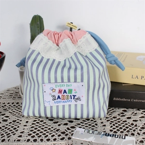 Detail of cute striped drawstring pouch with pink lace trim and rabbit graphic decoration