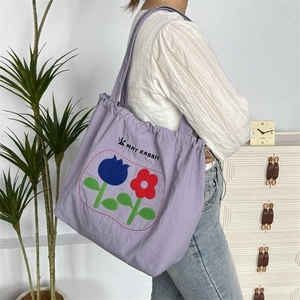 Detailansicht der lila Nylon-Tasche mit Blumenmuster und May Rabbit Logo-Schriftzug