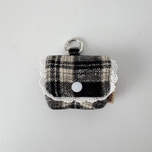 Close-up of black and white checkered earphone pouch with lace trim and silver metal hook