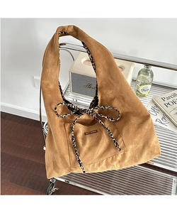 Detail of camel corduroy tote bag showing leopard print lining and front bow detail