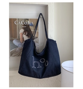 Detail of retro denim tote bag featuring white contrast stitching and hoo letter print