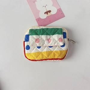 Close-up of quilted stripe mini wallet with snap button and silver zipper ring detail