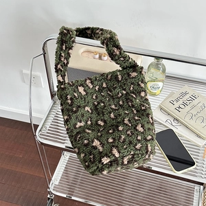 Green leopard print faux shearling bucket bag with wide top handle for winter fashion
