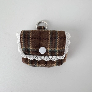 Close-up of brown plaid tweed earphone case with white lace trim and metal clip