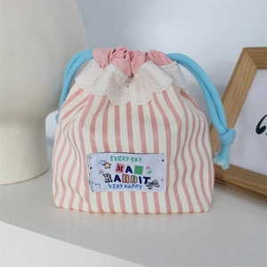 Detailed view of pink striped drawstring bag with white lace trim and blue cords