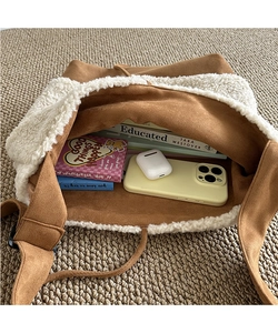 Top view of spacious interior of brown suede tote bag with white faux shearling trim
