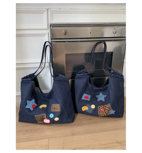 Detail of vintage denim tote bag featuring star patches and leopard print elements
