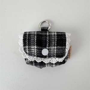 Close-up of black and white checkered earphone pouch with lace trim and metal clip