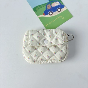 Detail view of quilted floral coin purse with resin snap button and metal ring zipper