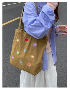 Detail of embroidered sea life patterns with jellyfish and starfish on a canvas tote bag