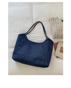 Flat lay of vintage blue denim tote bag with fine stitching details and double straps