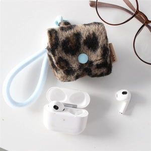 Macro detail of plush leopard print earphone case with blue button and woven strap
