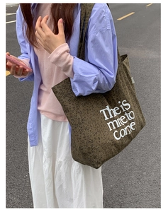 Detail of leopard print tote bag showing thick canvas texture and white letter embroidery