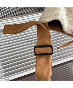 Detailed macro view of plush lamb wool lining and brown suede fabric with buckle