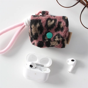 Macro detail of plush leopard print headphone case with soft texture and green button