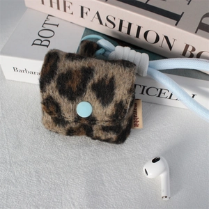 Detail of leopard print plush earbud case featuring blue button and braided lanyard