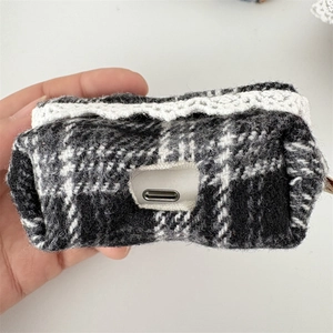 Detail of checkered tweed earphone case featuring white lace trim and USB-C port