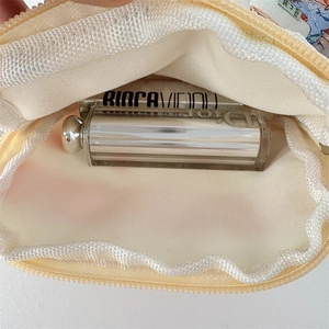 Internal view of the quilted floral pouch showing storage capacity for small cosmetics