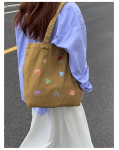 Detail of canvas tote bag with colorful embroidery of jellyfish and starfish patterns