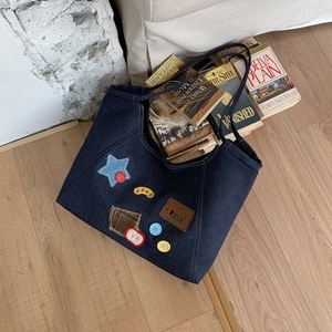 Retro dark blue denim tote bag with vintage patches and letter print on wooden floor
