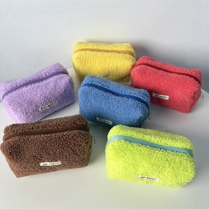 Close-up of soft sherpa pencil cases in vibrant colors with top zipper and woven label