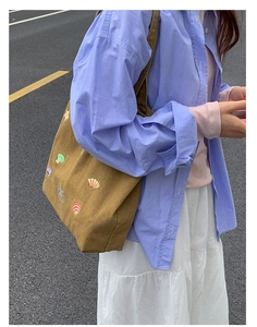 Detail of brown canvas tote bag featuring colorful seashell and starfish embroidery