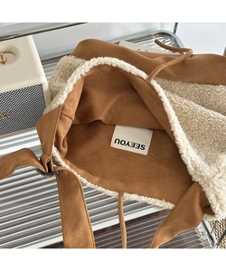 Detail of suede crossbody bag with soft faux shearling trim and inner SEEYOU brand tag