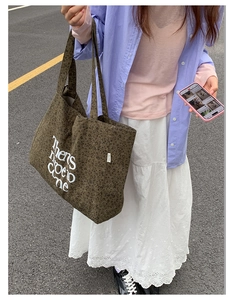 Close-up of leopard print canvas tote bag with white art lettering and brand label detail