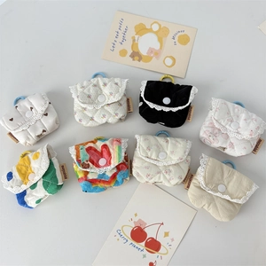 Flat lay of quilted floral headphone pouches in multiple colors with lace trim and clips