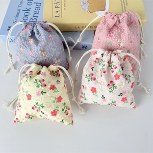 Detail of four colorful drawstring pouches with cartoon bears and floral quilted fabric